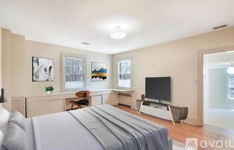 A bedroom with a large bed and a television in the corner.