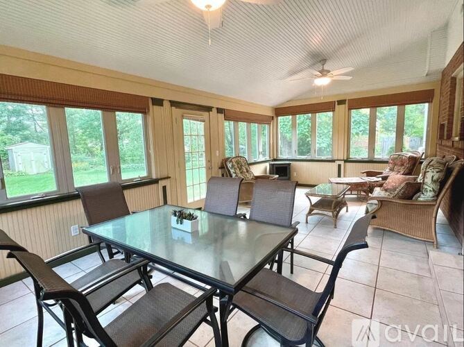 A sunroom with a glass table and chairs.