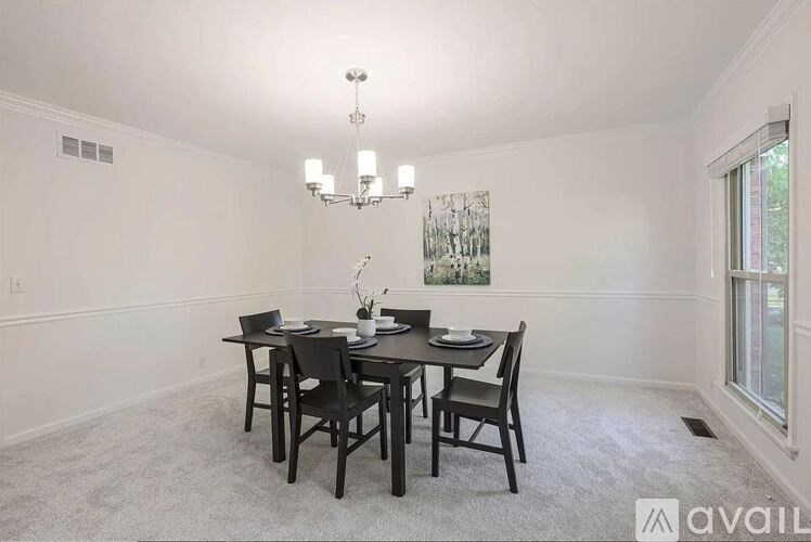 A dining room with a table set for four.
