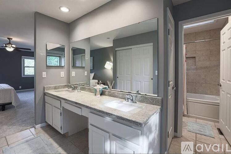 A bathroom with a double sink vanity and a large mirror.