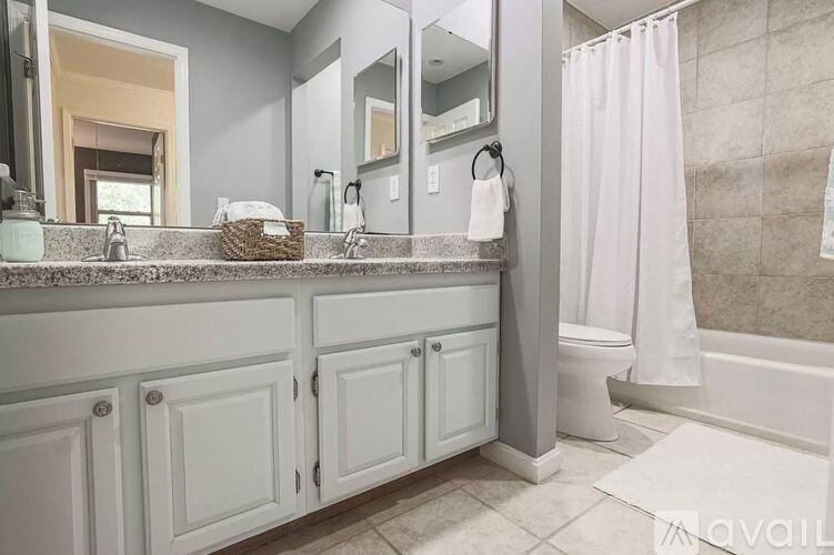 A bathroom with a white counter and a white shower curtain.