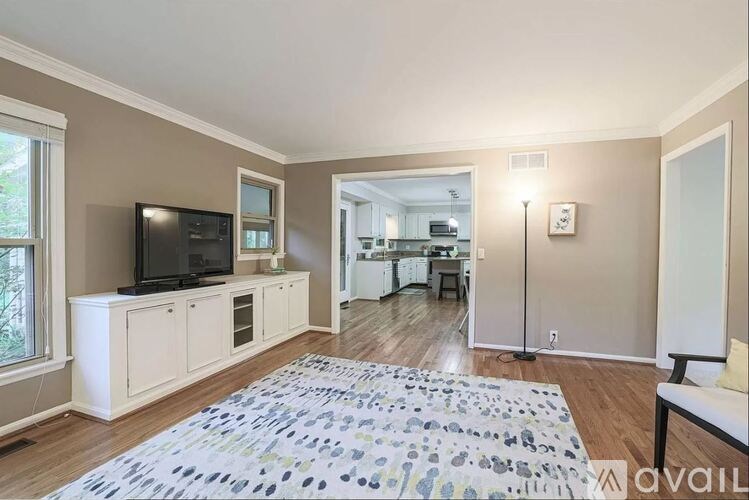 A living room with a television and a rug on the floor.