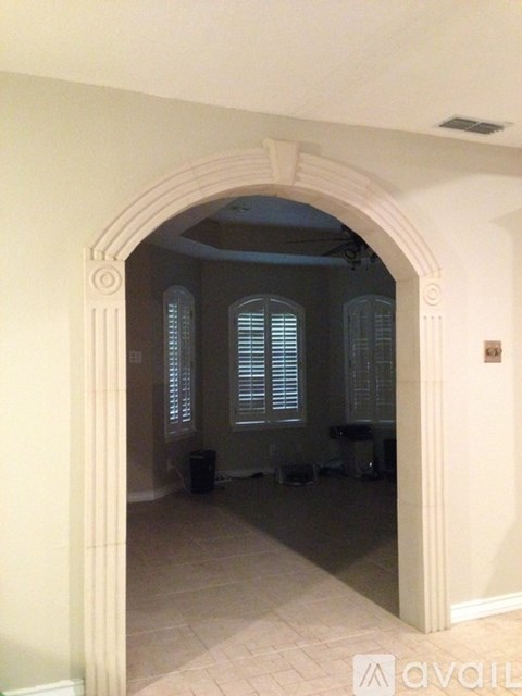 A room with a window and a trash can.