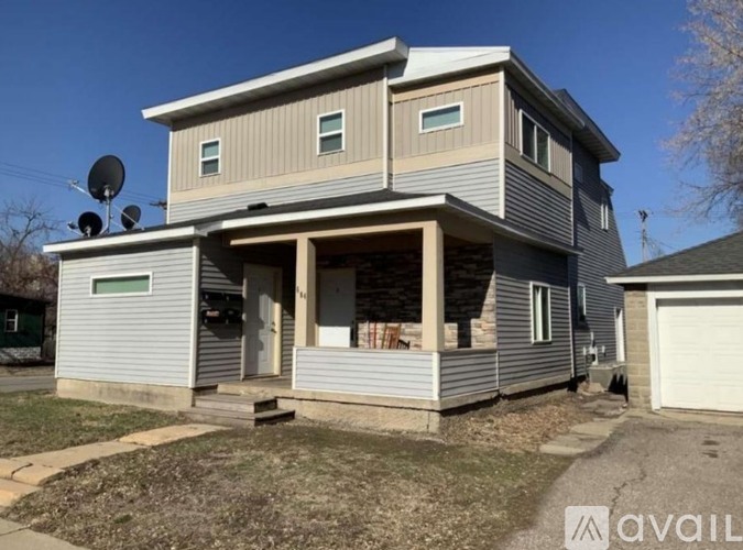 A two-story house with a garage on the ground floor and a balcony on the upper floor.