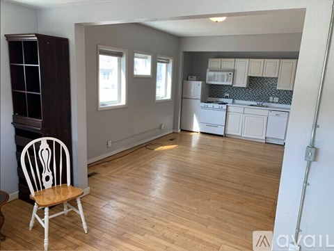 A kitchen with a wooden floor and white walls.