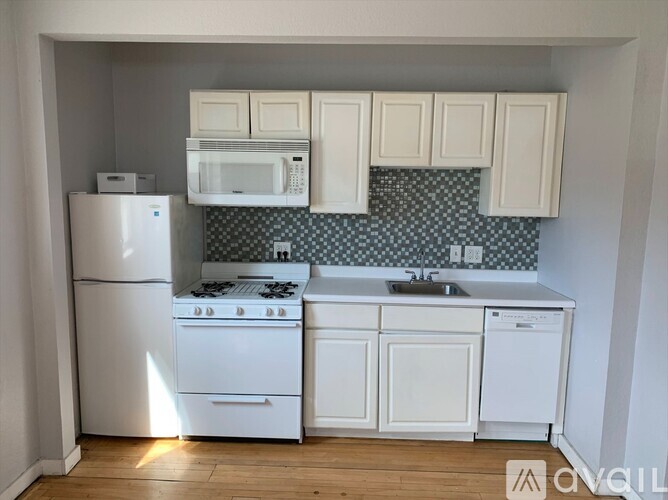 A kitchen with white appliances and cabinets.