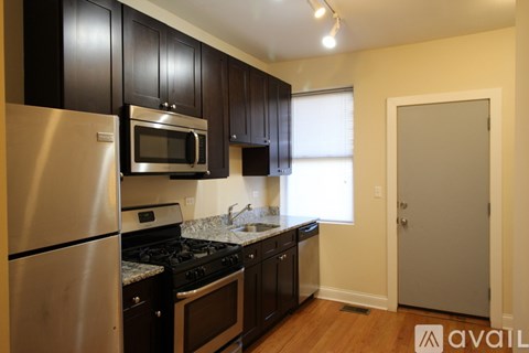 A kitchen with black cabinets and stainless steel appliances.