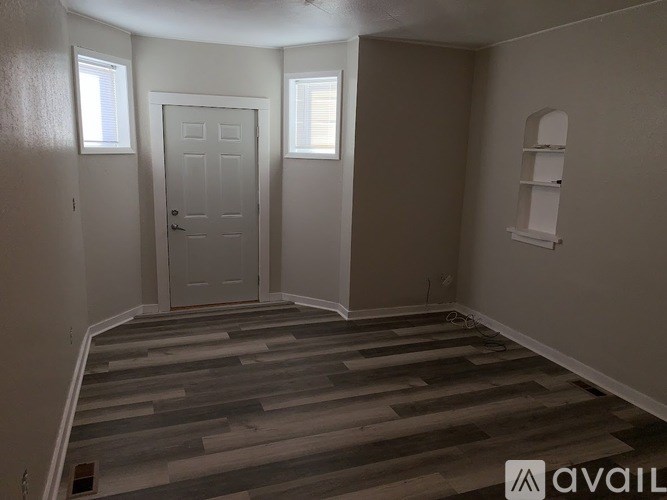 A room with a wooden floor and a white door.