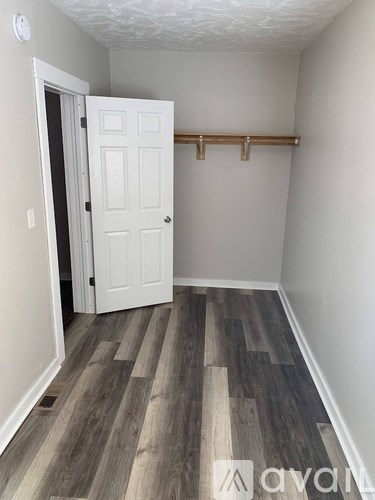 A white door is in a room with wood flooring.