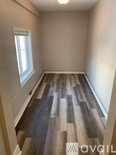 A room with wooden flooring and a window.