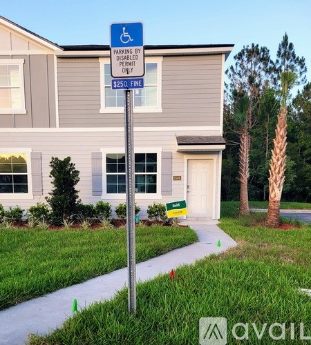 A sign in front of a house states that the parking is for disabled permit holders only.