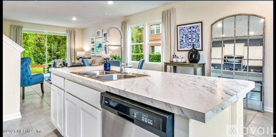 A modern kitchen with a marble countertop and a dishwasher.