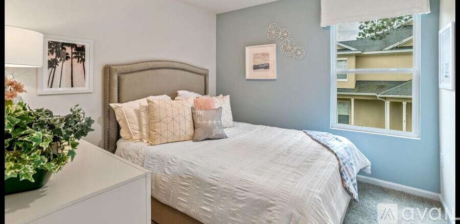 A bedroom with a large bed and a window overlooking a balcony.