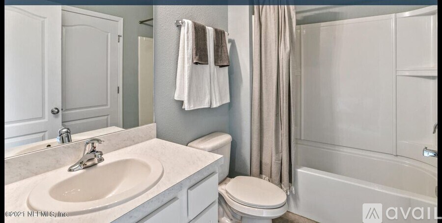 A bathroom with a sink, toilet, and shower.