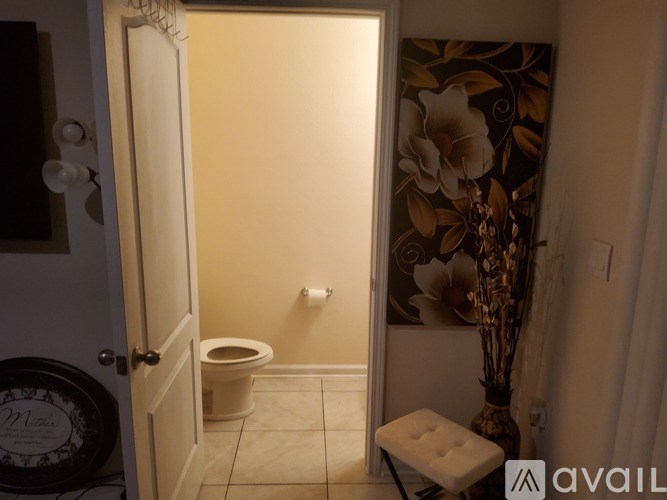A bathroom with a toilet and a vase.