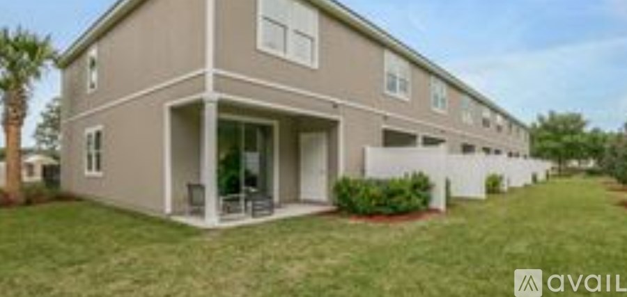 A beige house with a white fence and a patio.