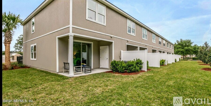 A building with a beige exterior and a white fence in front.