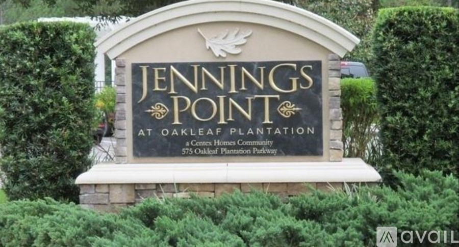 A sign for Jennings Point at Oakleaf Plantation is displayed in front of some greenery.