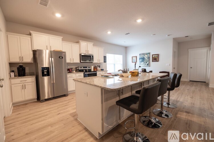 A kitchen with a refrigerator, microwave, and oven.