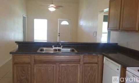 A kitchen with wooden cabinets and a black countertop.