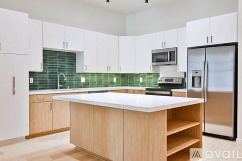 A kitchen with white cabinets and a wooden island.