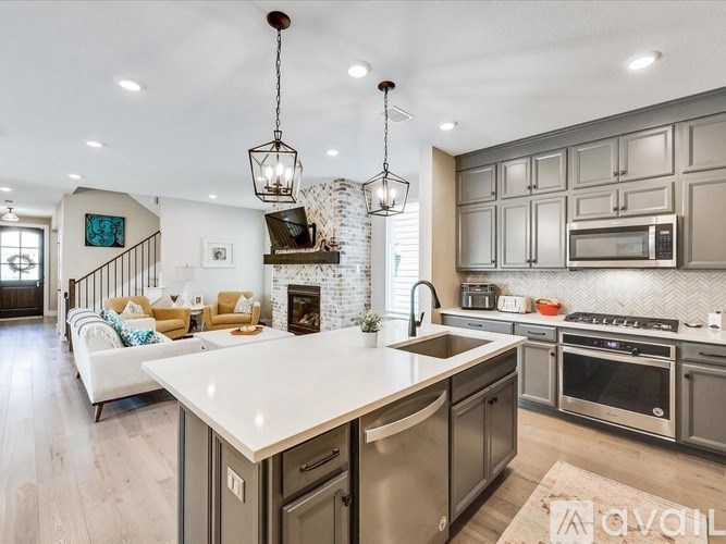 A modern kitchen with a large island and stainless steel appliances.