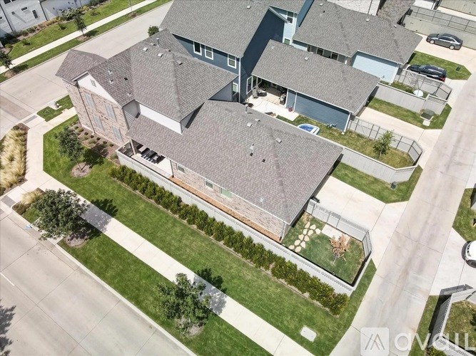 A large house with a grey roof and a long driveway.