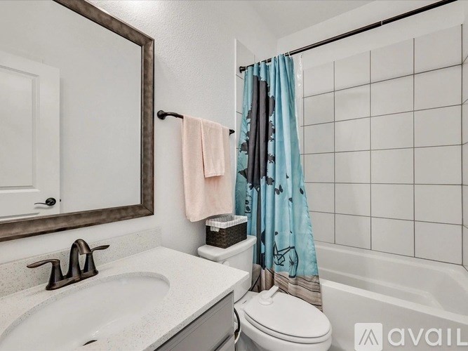 A bathroom with a white sink, toilet, and a mirror.