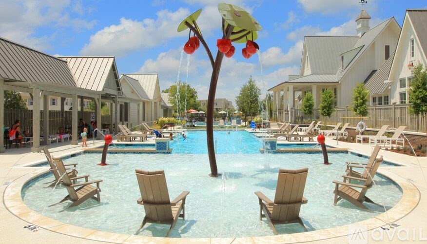 A pool with chairs and a tree in the middle of it.