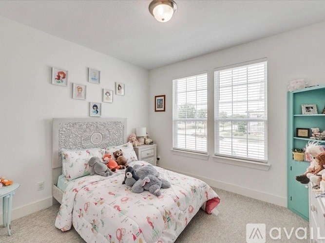 A bedroom with a large bed and a wall of pictures.