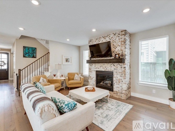 A living room with a fireplace and a television above it.