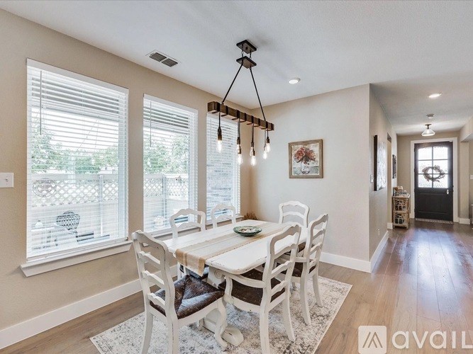 A dining room with a white table and chairs.