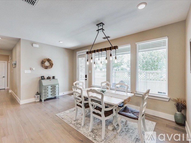 A dining room with a white table and chairs.