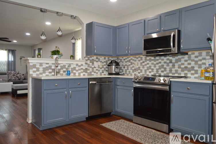 A kitchen with blue cabinets and a checkered backsplash.