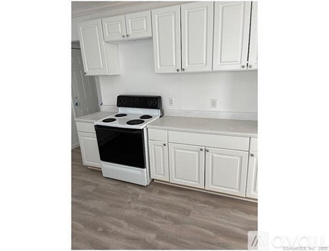 A white kitchen with a stove and cabinets.