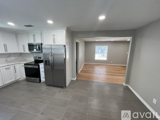 A kitchen with a refrigerator, microwave, and oven.