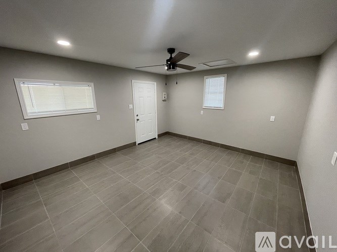 A room with a ceiling fan and tile flooring.