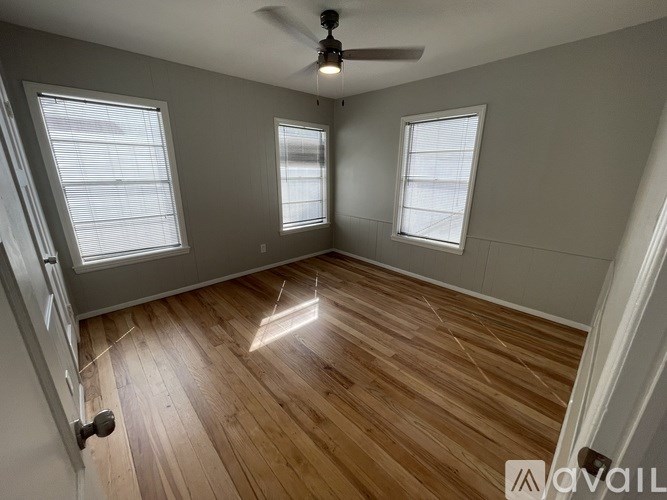 A room with wooden flooring and a ceiling fan.
