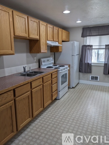 A kitchen with wooden cabinets and a white refrigerator.