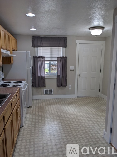 A kitchen with a white fridge and wooden cabinets.