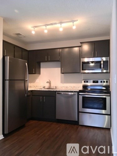 A kitchen with a refrigerator, oven, and microwave.