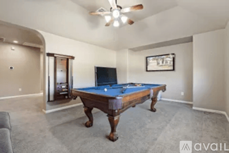 A room with a pool table and a television.