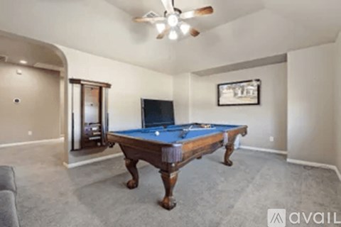 A room with a pool table and a television.