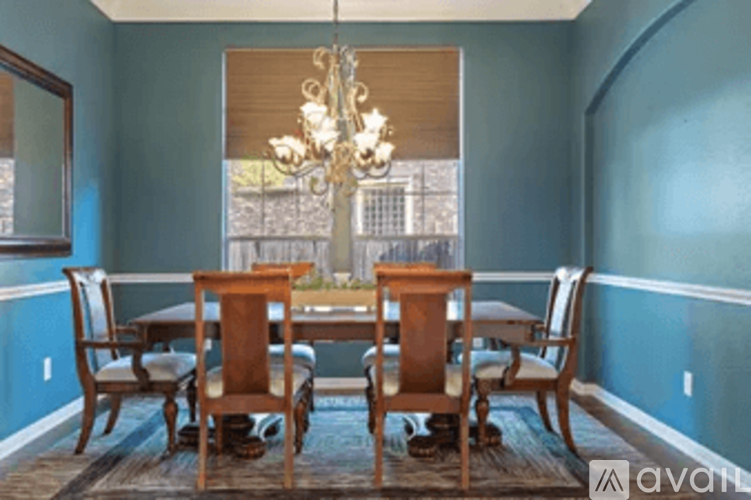 A dining room with a table and chairs.