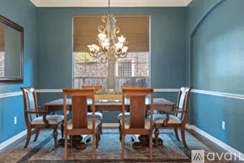 A dining room with a table and chairs.