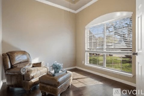 A living room with a brown leather chair and ottoman.