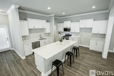A kitchen with white cabinets and a large island.