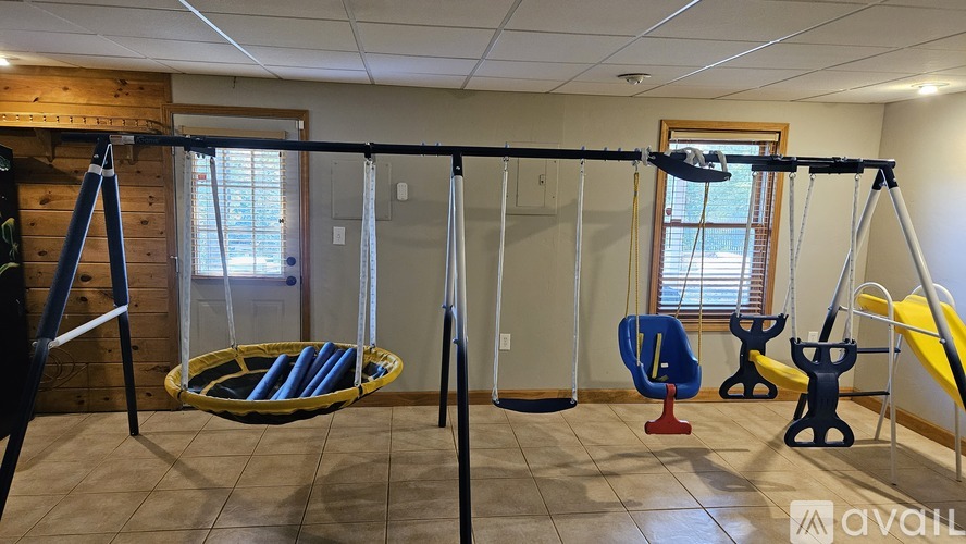 A gym with a variety of equipment including a squat rack, bench, and a pull up bar.