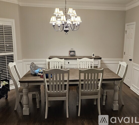 A dining room with a wooden table and chairs.