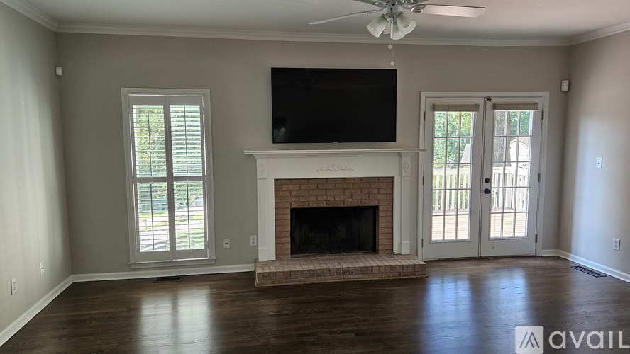 A living room with a fireplace and a flat screen TV mounted above it.